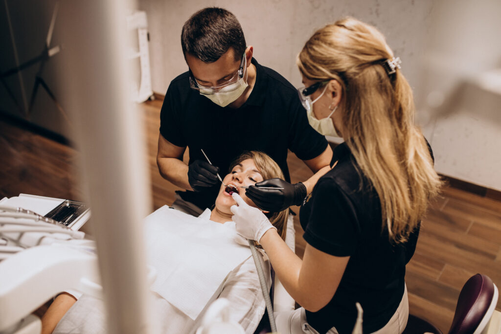 Dentist and dental assistant treating a patient in a dental practice
